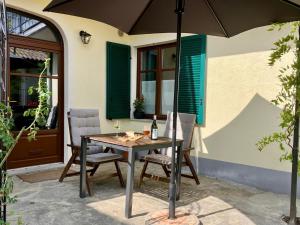 a table and chairs with an umbrella on a patio at Casavabene Appartamenti - for hikers, bikers and slow travelers in Murazzano