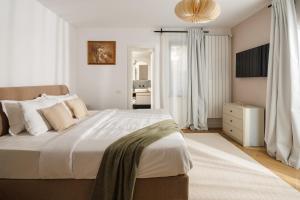 Un dormitorio con una cama grande con sábanas blancas. en Citadel Signature Villa, en Brasov
