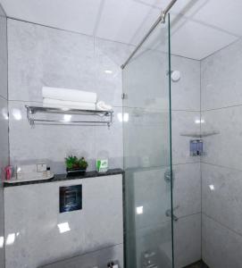 a shower with a glass door in a bathroom at Parkwood Elite in Bengaluru