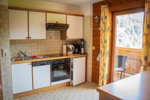 a kitchen with a sink and a stove at Ferienwohnung Schoberhof in Filzmoos +6 photos