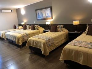 a hotel room with three beds in a room at Orquideas Hotel & Cabañas in Puerto Iguazú +60 photos