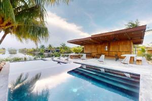 a villa with a swimming pool and a house at Seabird Villa 23 in Placencia Village +3 photos