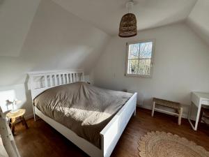 a bedroom with a white bed and a window at Maison paisible à 5 minutes à pied de la plage in Audinghen
