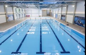 a large indoor swimming pool with blue water at Studio Crnjanski in Jagodina