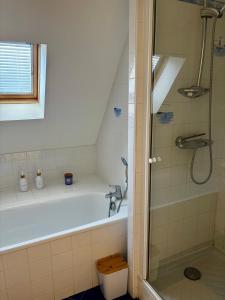 a bathroom with a bath tub and a shower at Maison paisible à 5 minutes à pied de la plage in Audinghen