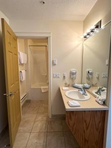 a bathroom with a sink and a mirror at Western Budget Motel Ponoka in Ponoka +42 photos