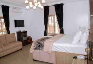 a bedroom with a large bed and a couch at Deluxe Indulgence Hotel & Suites in Mama +13 photos