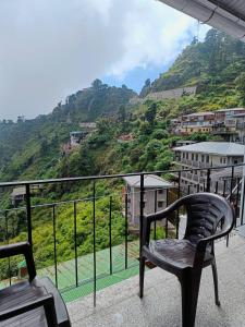 una sedia su un balcone con vista sulle montagne di After Dun Delight a Mussoorie Altre 2 foto