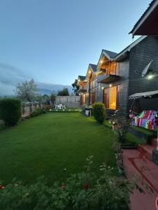 a backyard of a house with a large lawn at Cliffside cottage in Tangmarg +14 photos