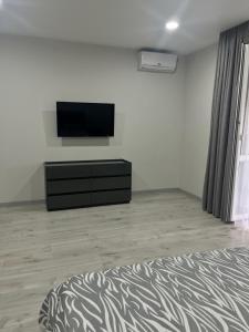 une chambre avec un lit et une télévision sur un mur dans l'établissement 1-комнатная квартира, à Tchornomorsk