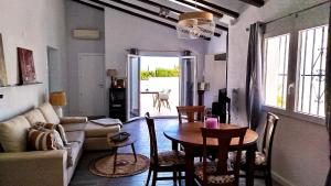 ein Wohnzimmer mit einem Tisch und einem Sofa in der Unterkunft Naranjos House in Muntanya la Sella