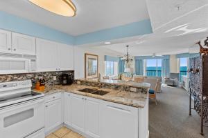 a kitchen with white cabinets and a living room at Ashworth 1709 in North Myrtle Beach