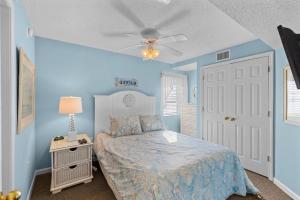 a bedroom with a bed and a blue wall at Ashworth 1709 in North Myrtle Beach +28 photos