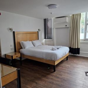 a bedroom with a large bed with white sheets at The Dorchester Hotel & serviced apartments FREE PARKING in Hull