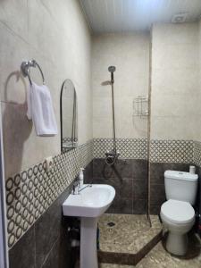 Un baño con lavabo, inodoro y ducha. en Your Comfort, en Kutaisi
