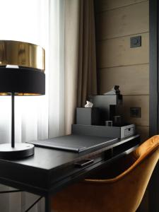 a desk in a hotel room with a lamp and a chair at SEOVILLAGE Resort & Spa in Ķeipene +48 photos
