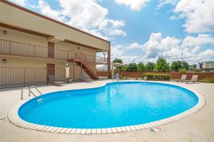 a swimming pool in front of a building at Best Western Airport Inn in Pearl