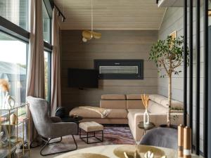 a living room with a couch and a tv at SEOVILLAGE Resort & Spa in Ķeipene