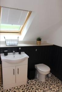 a bathroom with a sink and a toilet with a skylight at 3 Bed Cottage, Melrose-Log Burner and Eildon Views in Melrose +6 photos