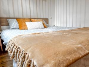 a bed with orange and white pillows in a bedroom at 10 min to Old Town - Free Parking - Work Station in Tallinn