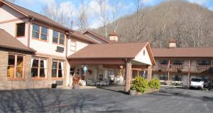 Un edificio con un estacionamiento enfrente. en Jonathan Creek Inn and Villas, en Maggie Valley