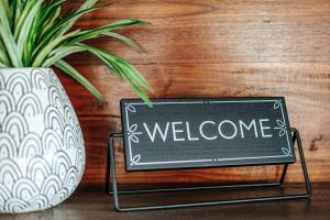 a sign with the word welcome next to a vase at Basecamp151 in Afton +49 photos
