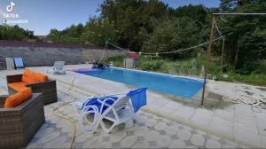una piscina con una silla y una mesa en Melek villa, en Gabala