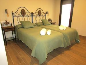 2 Betten mit weißen Kissen auf einem Zimmer in der Unterkunft Casa Rural El Parque in Navalcán + 31 Fotos