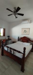 a bedroom with a bed with a ceiling fan at Pousada e Pub Chalé do Rock in São João Batista do Glória