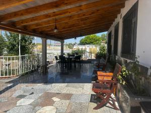 een patio met een tafel en stoelen onder een houten pergola bij Casa campo de 3 habitaciones con parcela in Villamayor