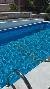 een zwembad met blauw water erin bij Casa campo de 3 habitaciones con parcela in Villamayor