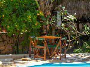 a table and chairs sitting next to a pool at Casa de hóspedes Balibar Cumbuco in Cumbuco