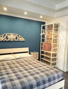 a bedroom with a bed and a blue wall at Chez Nous in La Spezia