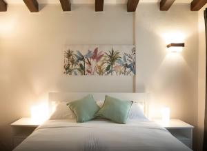 Un dormitorio con una cama con dos almohadas verdes. en La Ginestra, en Mossa