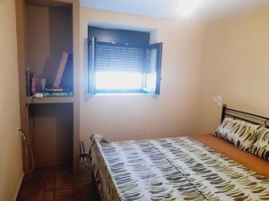 a bedroom with a bed and a window at MOMENTS of HAPPINESS in Soúrpi