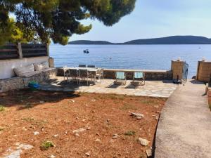 a patio with a table and chairs next to the water at MOMENTS of HAPPINESS in Soúrpi