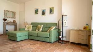 Una sala de estar con un sofá verde y una mesa. en ESSENZA di TOSCANA apartment with view, en Montepulciano 12 fotos más