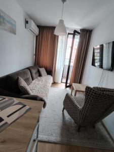 un soggiorno con un divano, sedie e un tavolo di Apartament Khan Kubrat a Sandanski
