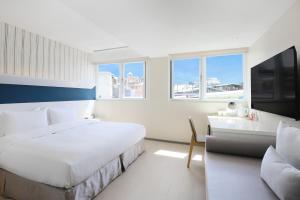 a white bedroom with a large bed and a couch at Dandy Hotel - Tianmu Branch in Taipei +50 photos