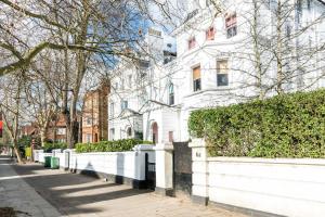 a white house with a fence in front of it at NEW Sleek and Stunning 1 Bedroom Flat Hampstead in London