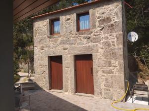 a stone building with two brown doors on it at Quinta do Chão do Vale in Sever do Vouga