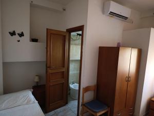 a bedroom with a bed and a cabinet and a toilet at L'Aragosta Guesthouse in Alghero