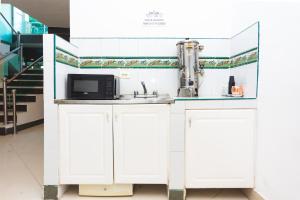 a white kitchen with a microwave and a sink at Hotel Villa Real 70 Laureles in Medellín +17 photos