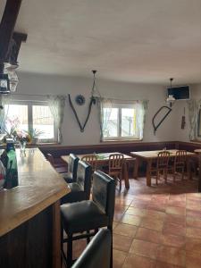 a restaurant with a bar and tables and chairs at Scherhäuflranch in Mönchdorf
