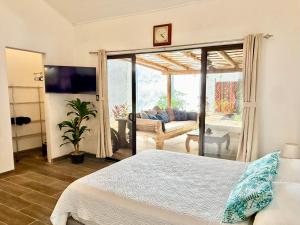 a bedroom with a bed and a living room at Passion For Surfing Apt Playa Guiones in Playa Guiones