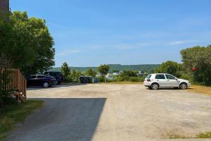 a parking lot with two cars parked in it at Elegant Escape, Modern Luxe in Historic Suite in Saint John