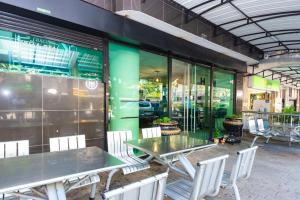 a restaurant with tables and chairs and a green wall at Hotel Villa Real 70 Laureles in Medellín