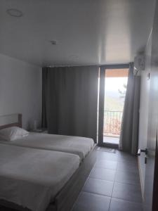 a bedroom with a bed and a sliding glass door at Quinta do Chão do Vale in Sever do Vouga +14 photos
