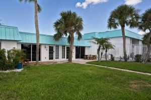 a building with palm trees in front of it at #1 Beach Siesta Key Village w heated pool & arcade in Sarasota