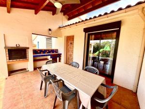 una sala da pranzo con tavolo e sedie su un patio di Maison avec piscine VIVES 8 couchages 4 chambres a Vivès